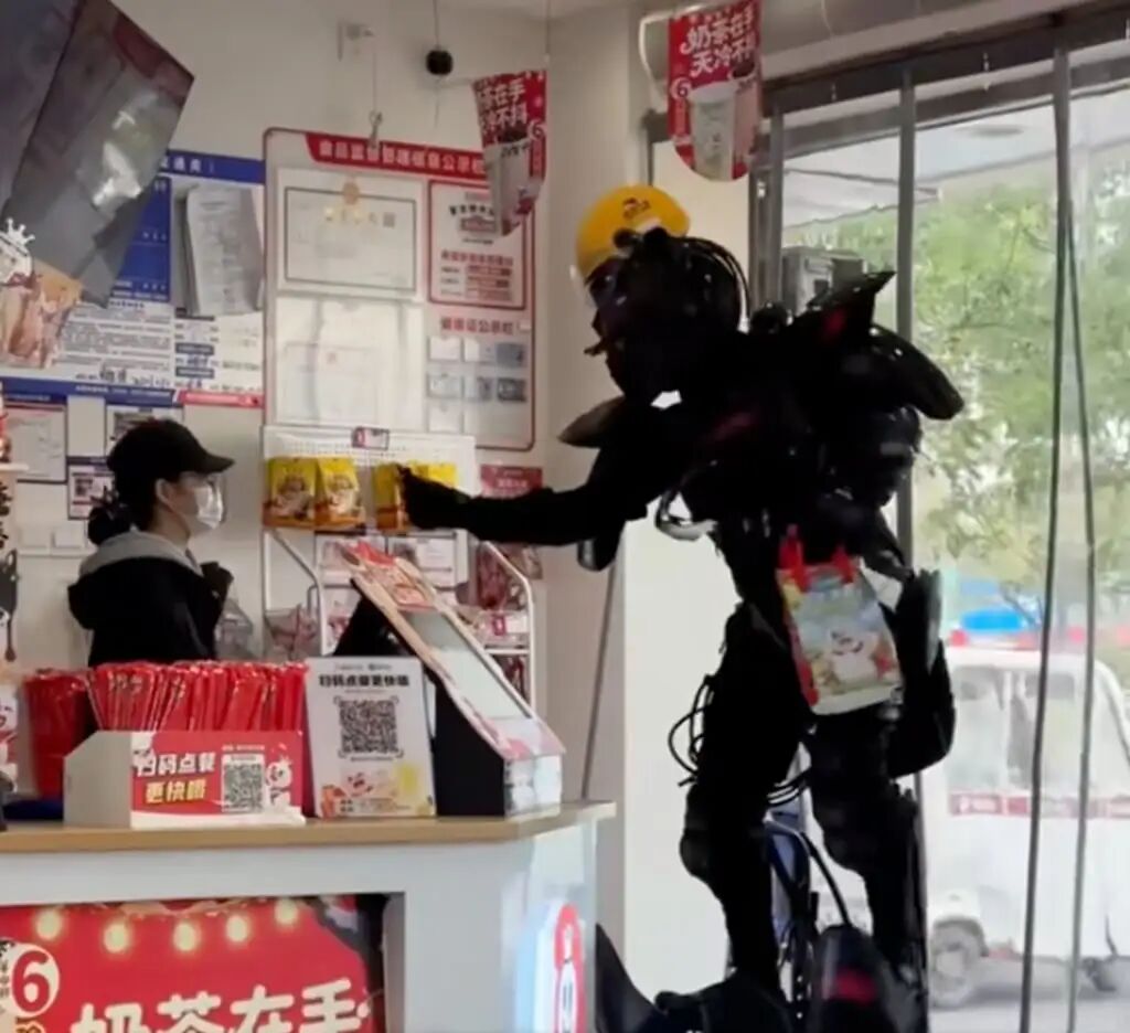 Zhou Gaosai picks up an order from a shop while kitted out in his mecha suit. Photo: QQ.com