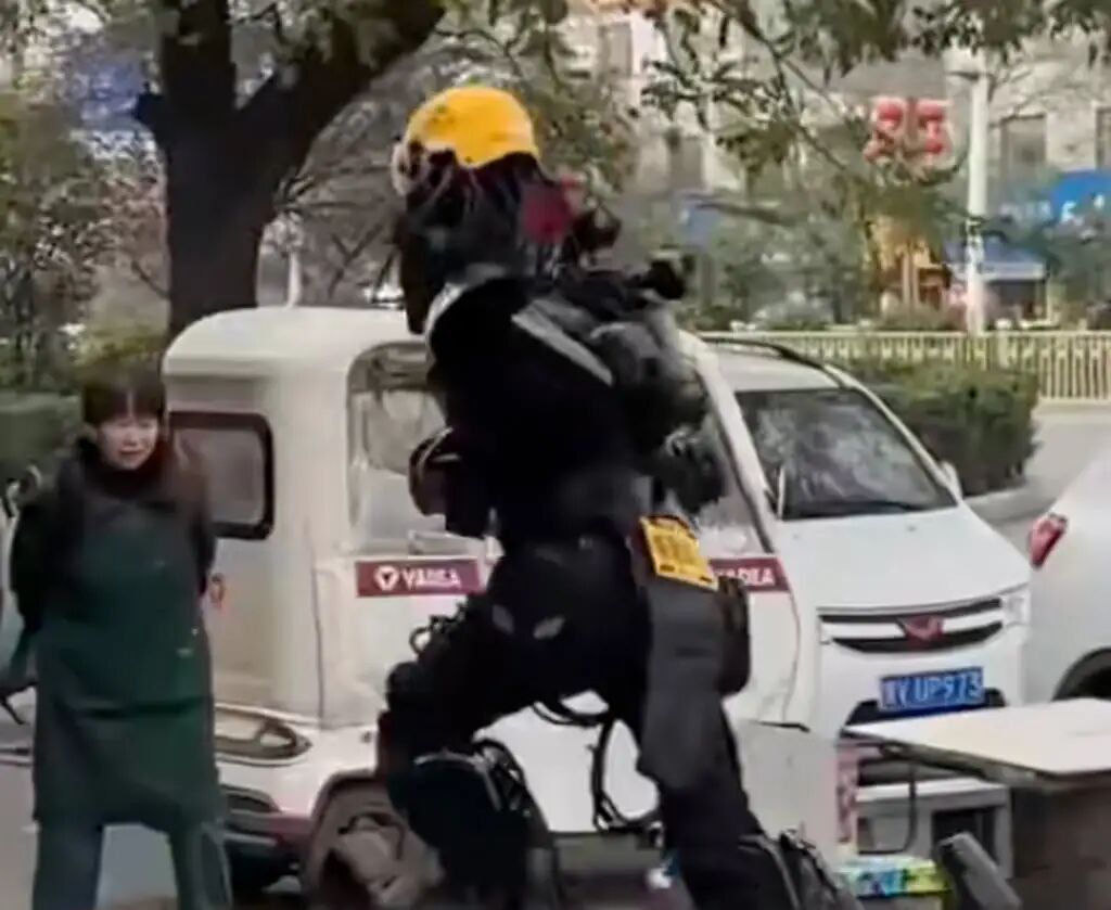 A perplexed woman looks on as Zhou runs past her on the street with a delivery. Photo: QQ.com