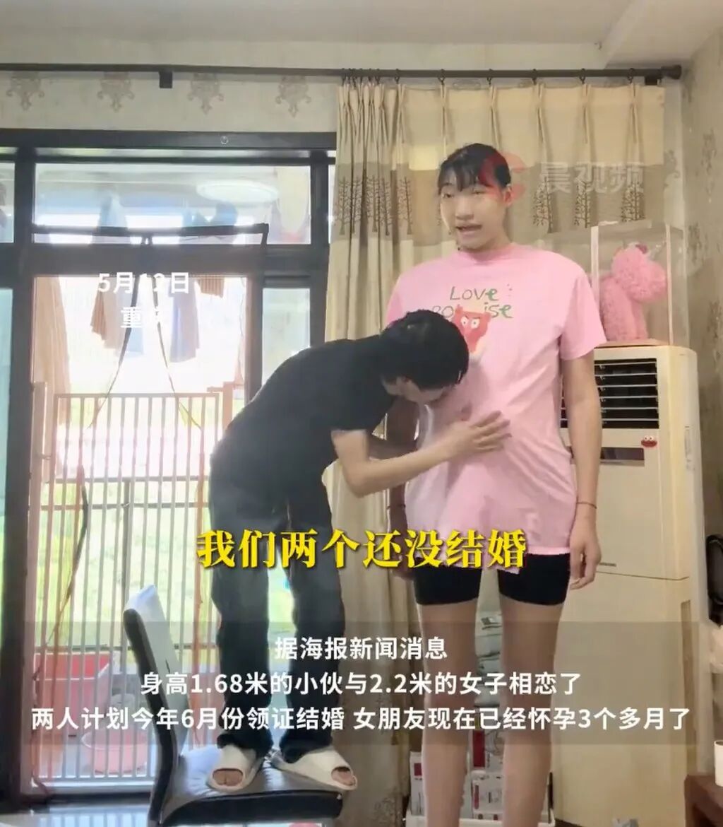 Zihao stands on a chair to rub the belly of his girlfriend who is expecting a baby. Photo: 163.com