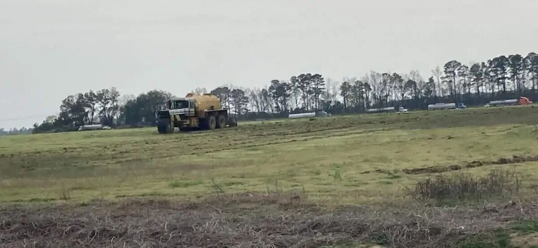 Heavy machinery spreads sludge on a field in Darlington County, SC. Photo taken March 2023.