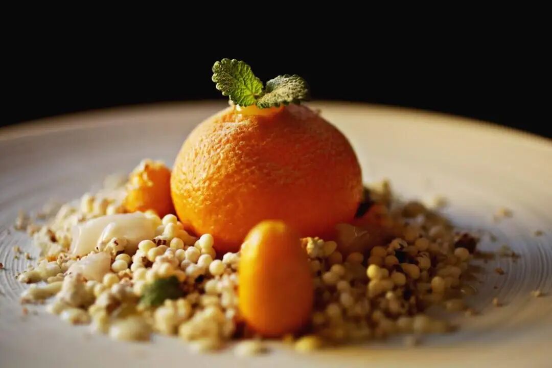 This chicken liver dish with creme fraiche and lemon balm from Herons is served inside citrus atop a bed of puffed grains.