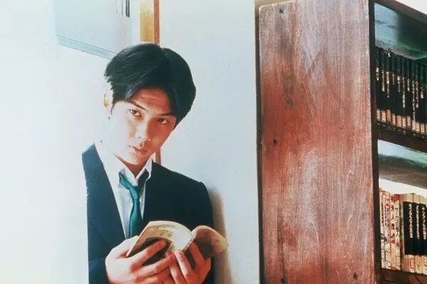 《情书》中柏原崇站在窗前读书