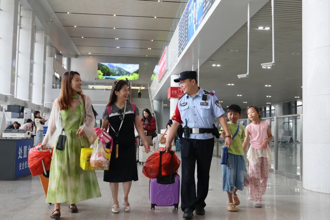 天津铁路公安处北戴河站派出所民警帮助旅客拿行李，确保旅客和儿童能够顺利乘车。.JPG