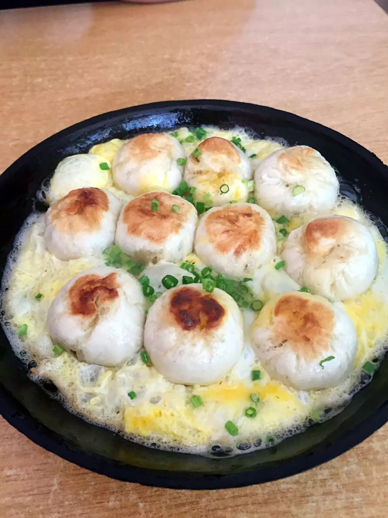 鸡蛋液然后放到小铁锅里煎这个是蒸好的小笼包这个和上海那种生煎包不