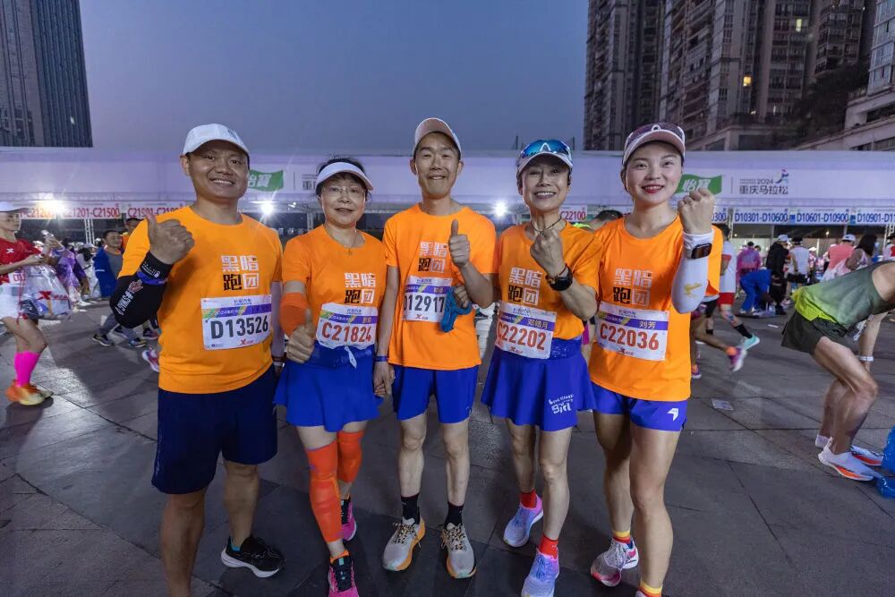 视障跑者喻春(中)和他的陪跑员杨飞(左一),贾琼(左二),邓皓月(右二)