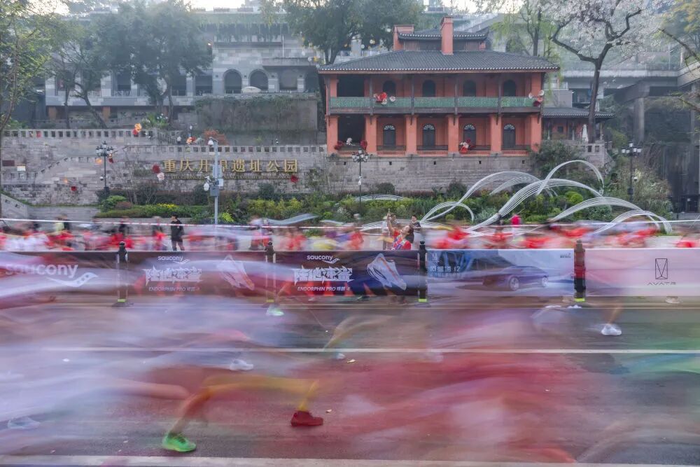 新华社记者 黄伟 摄视障跑者喻春(中)和他的陪跑员杨飞(左一),贾琼(左