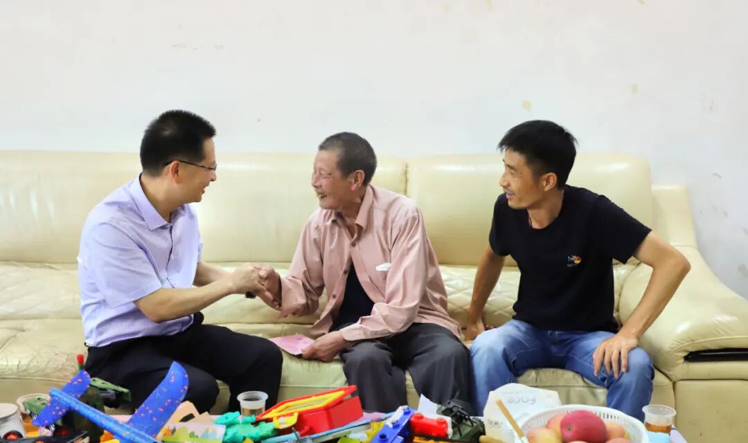 " 来到90岁的困难党员马隆庭家,连山县委书记许崇砚亲切地握住老人的