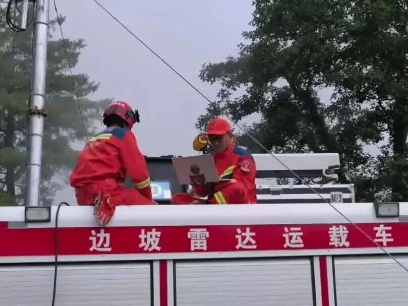 救援人员在边坡雷达运载车车顶研判数据