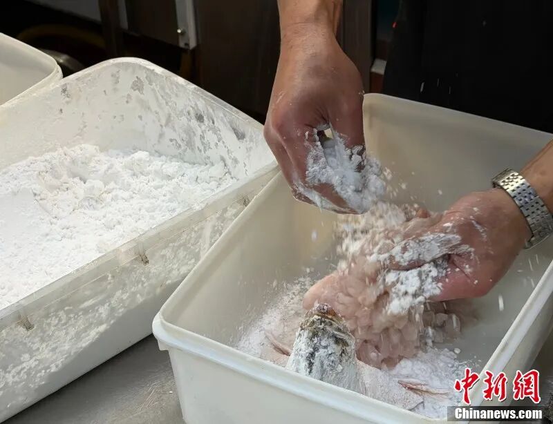 图为厨师将桂鱼裹满面粉。 卢梦梦 摄.jpg