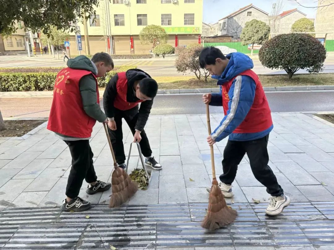 学生志愿者清扫街道.jpg