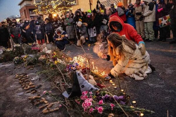 Minneapolis residents and mourners place candles and flowers on the ground at the spot where Alex Pretti was shot and killed by federal agents in Minneapolis.