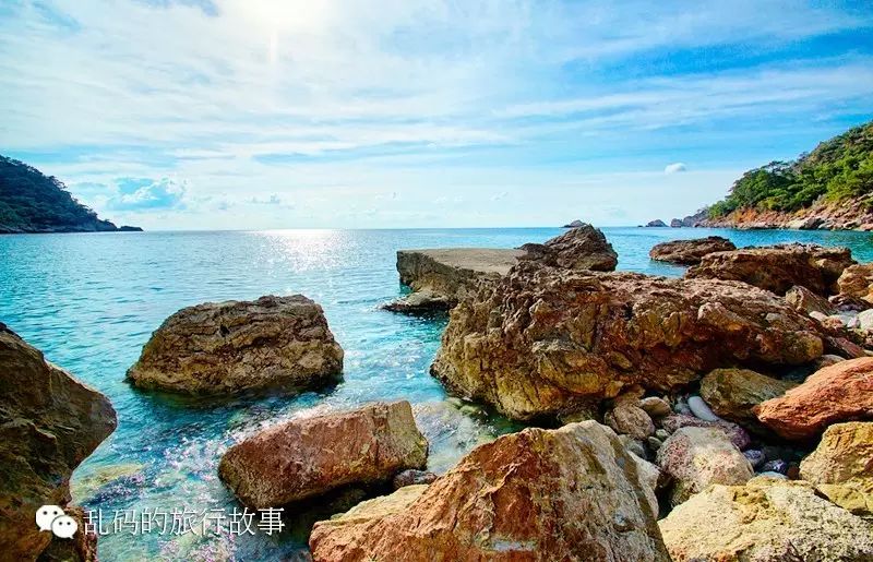 這片安靜的海灘水清湛藍,海浪輕柔適合游泳,遠處那塊平坦的礁石是練習