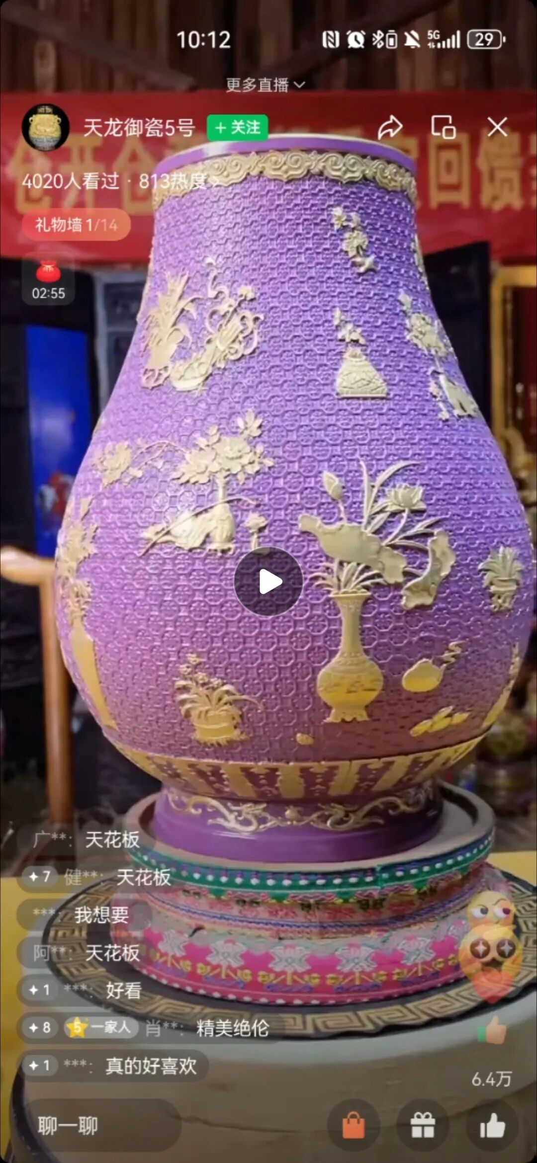 ▲主播展示了一件紫釉浮雕鎏金福筒尊。该瓷器为紫罗兰色，瓷器表面雕刻着八边形花卉纹路。直播截图