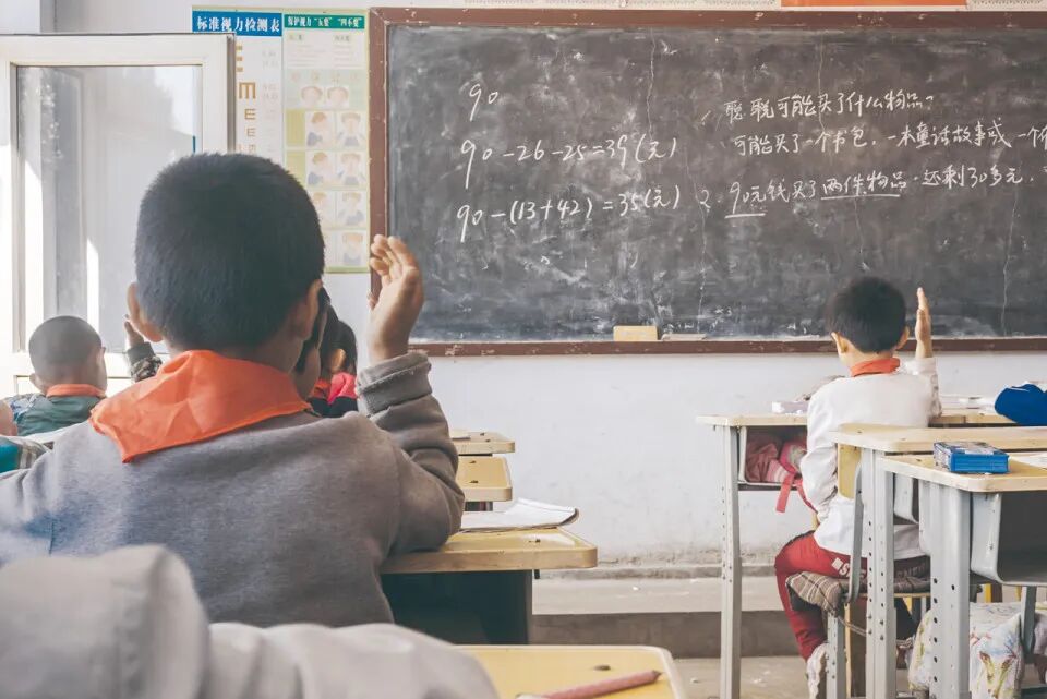 学生在课堂上举手回答问题，图源：图虫