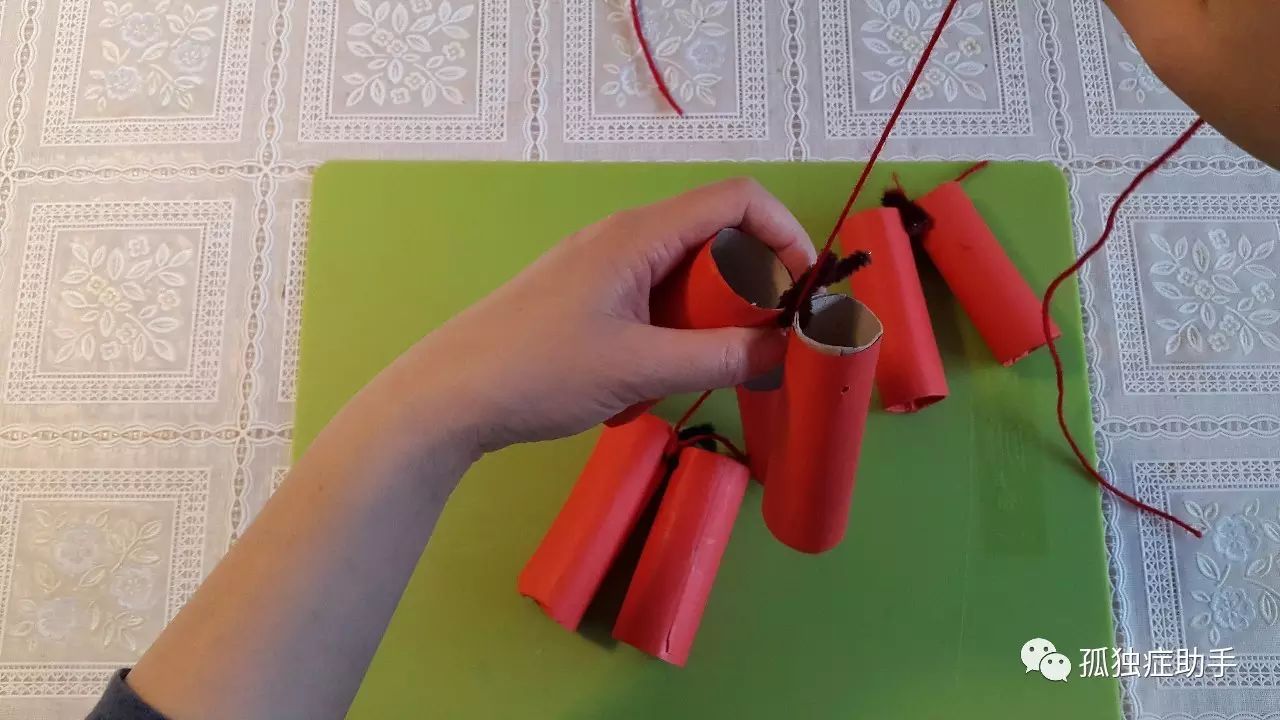 用红线绳把鞭炮穿起来