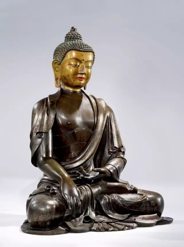 尊像头饰螺髪,排列规整,肉髻圆隆高凸,顶饰摩尼宝珠,额头扁平,面颊