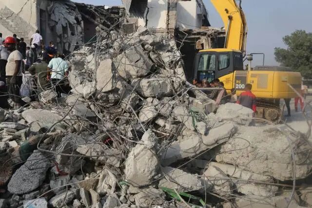 在伊朗南部米纳卜市一所被袭击的小学，救援人员和当地居民试图从废墟里营救伤员。新华社 发