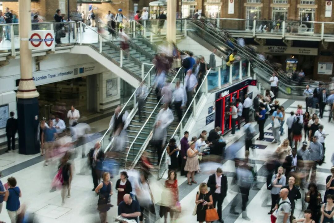 Commuters in motion on escalators and a concourse at Liverpool Street station in London