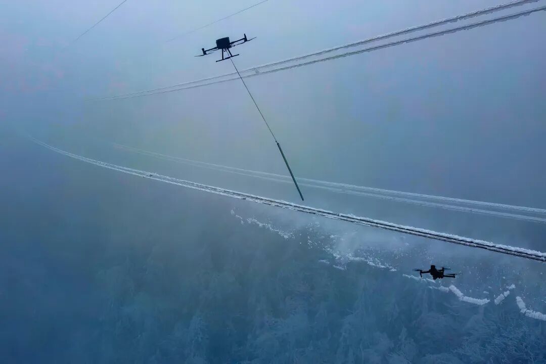 《无人机重“棒”出击保供电》2025年2月2日，在湖北十堰市茅箭区大川镇五条岭，国网十堰供电公司运维人员在220千伏十房线17~18号杆塔开展无人机除冰作业。郝金鑫 摄.jpg