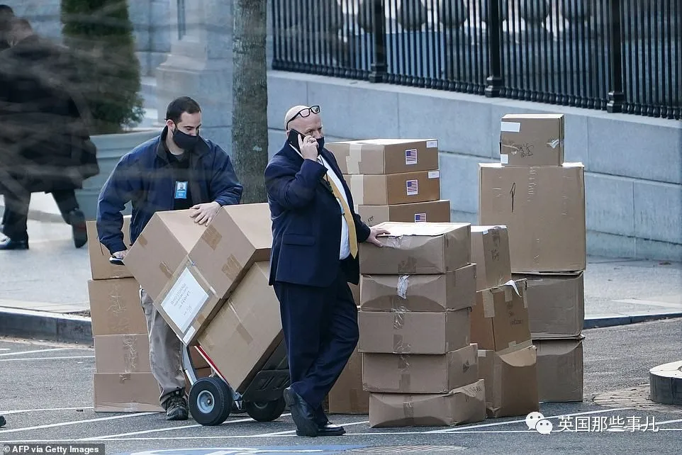 38033732-9149991-A_worker_stacks_boxes_on_West_Executive_Avenue_before_loading_th-a-83_1610696821829.jpg Image