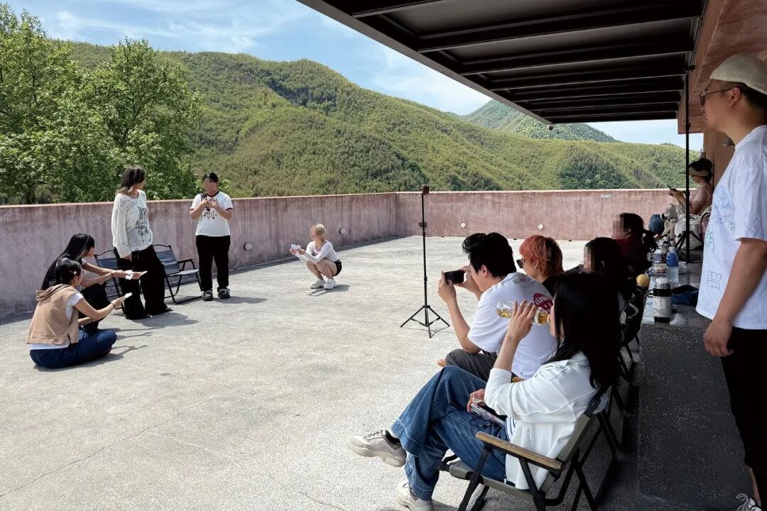 ▲2026年4月26日，“一出学社”的少年和导师们在莫干山木可社区天台排练即兴戏剧 图/南方人物周刊记者 邓郁