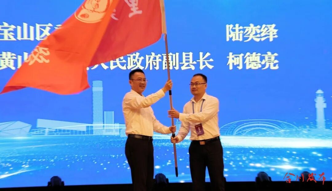 宝山区委副书记陆奕绎向下一届主办方代表黄山市歙县人民政府副县长柯德亮交接旗帜_副本.jpg