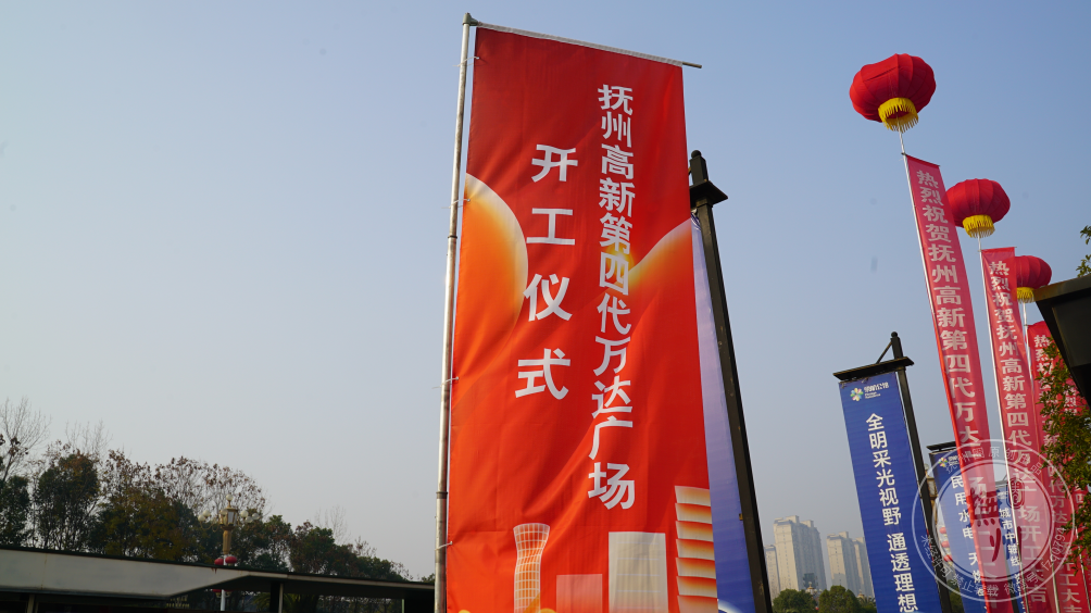 旁侧道旗,条幅上书"抚州高新第四代万达广场开工仪式"随风飘扬,仿佛在