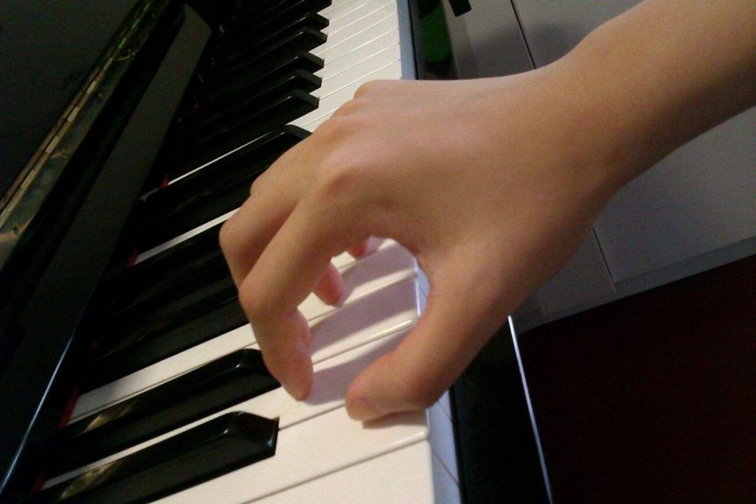 学生在演奏钢琴的时候要保持一个握鸡蛋手型,还会在手腕上放一个硬币