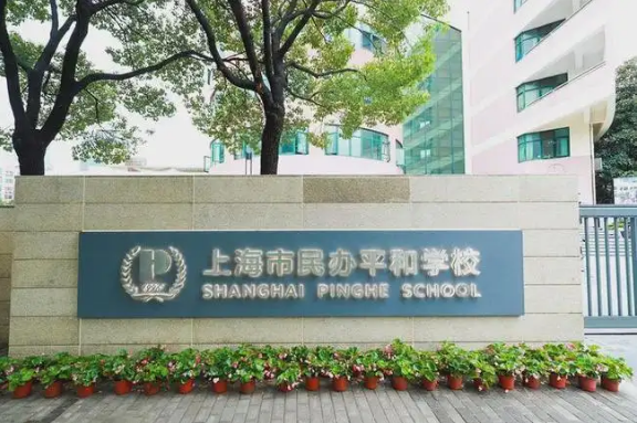 校名墙标示上海市民办平和学校，旁有树木和花盆。 · 图片来源：sh.xhd.cn