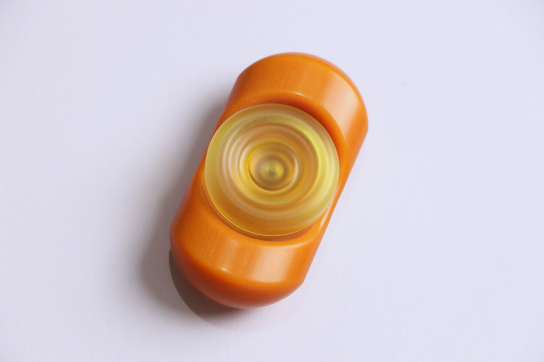 Another view of the orange Bakelite Yuandian, with its rounded body surrounding a pale yellow central button