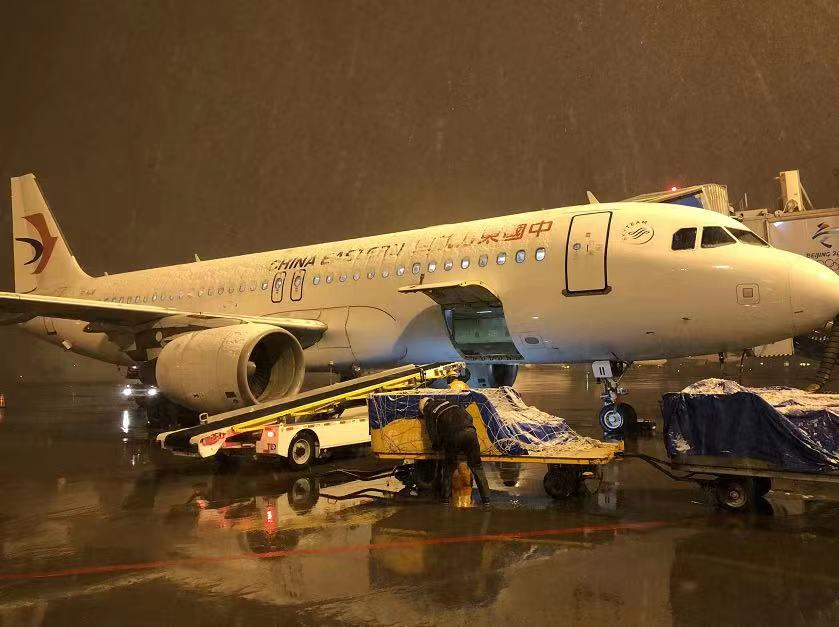 为了保障航班顺利出港,昌北机场地勤人员冒着风雪为机翼除冰,帮助旅客