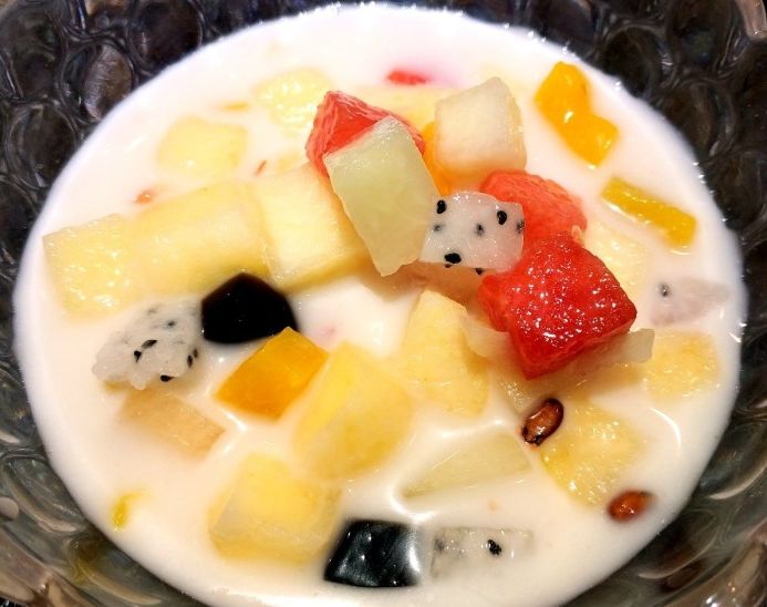 捞桌桌都摆着一桶,水果种类丰富又新鲜,苹果,西瓜,火龙果,龟苓膏,黄桃