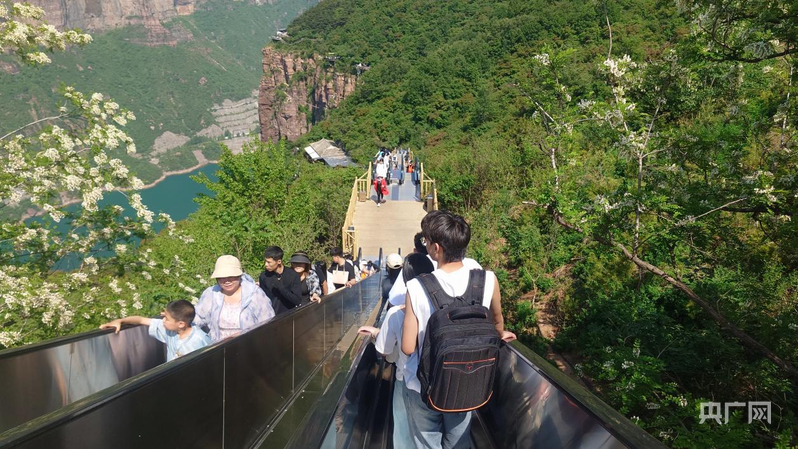 游客乘坐4部宽度可站立1人的连续扶梯上下行（央广网记者 夏莎 摄）