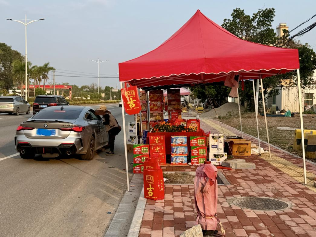 年例期间，路边流动摊贩常有顾客顺路咨询购买。