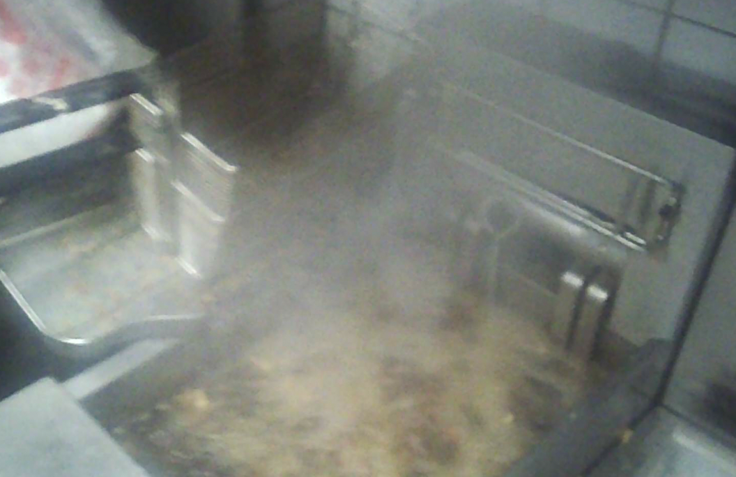 2月22日晚10时许，华莱士郑州百福街店的炸油已呈深褐色，炸制餐品时冒烟。（图源：新京报）