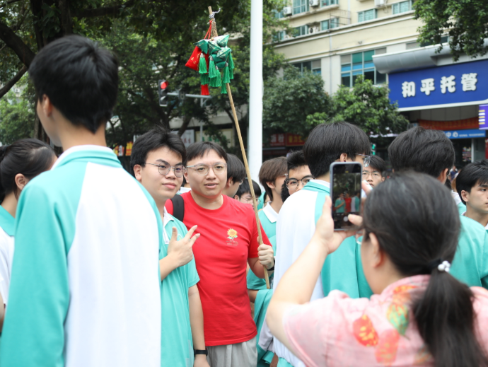 送考老师手举“高粽”，为步入考场的学子送上祝福。