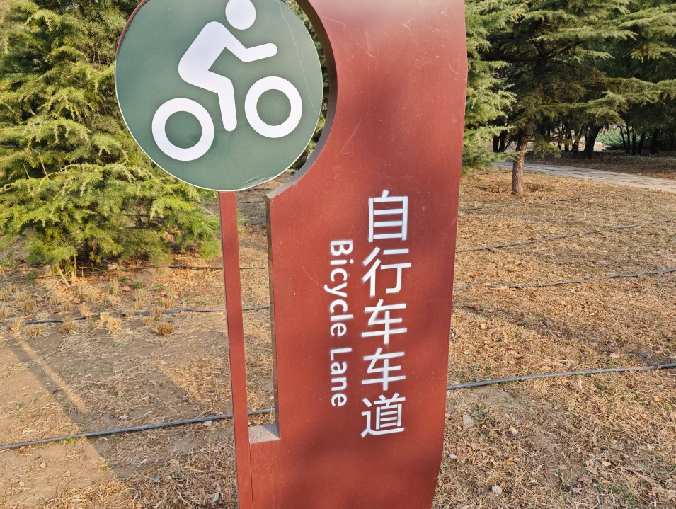 自行车车道既可以看到公园入口扭头向右看附近有老人在此锻炼有几尊