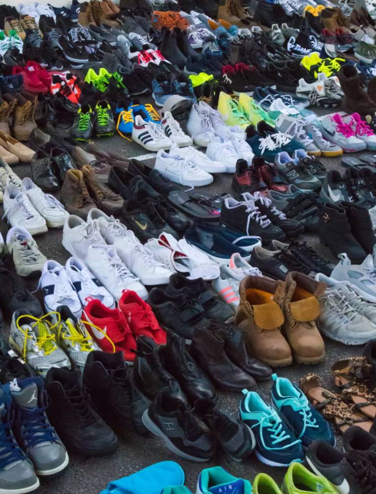 人们捐赠的鞋子,很多都是几乎全新的,堆满在一个篮球场上