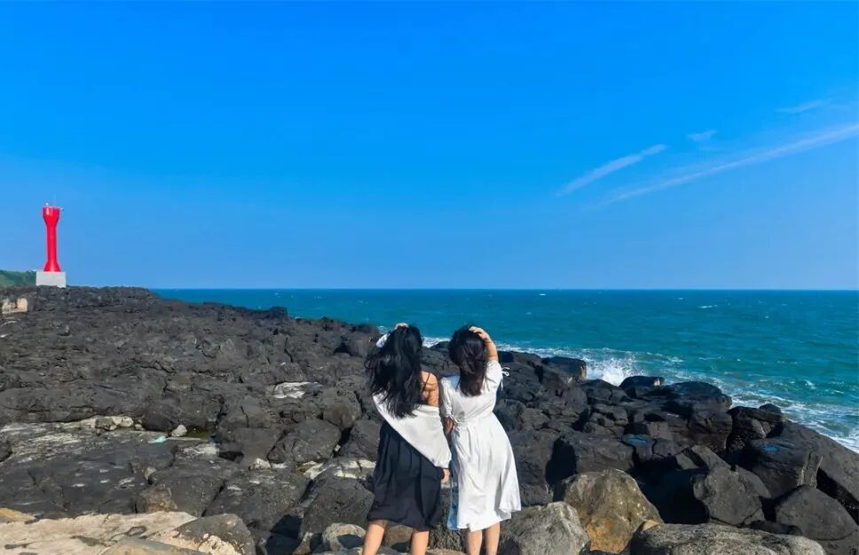 游客在那晏海石滩拍照打卡。