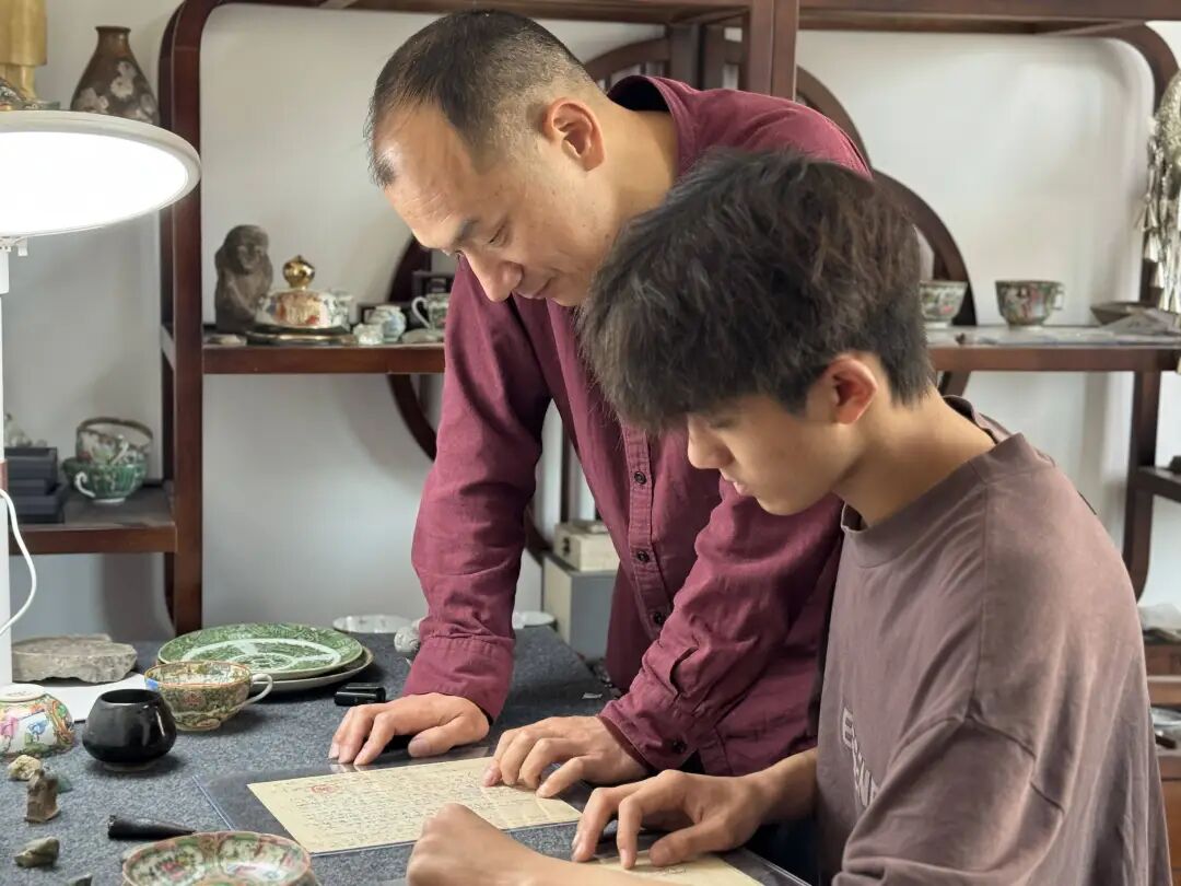 于聍鹏很喜欢和大伯一起研究自己收集到的文物史料。本报记者 孙亚妮 摄5555.jpg