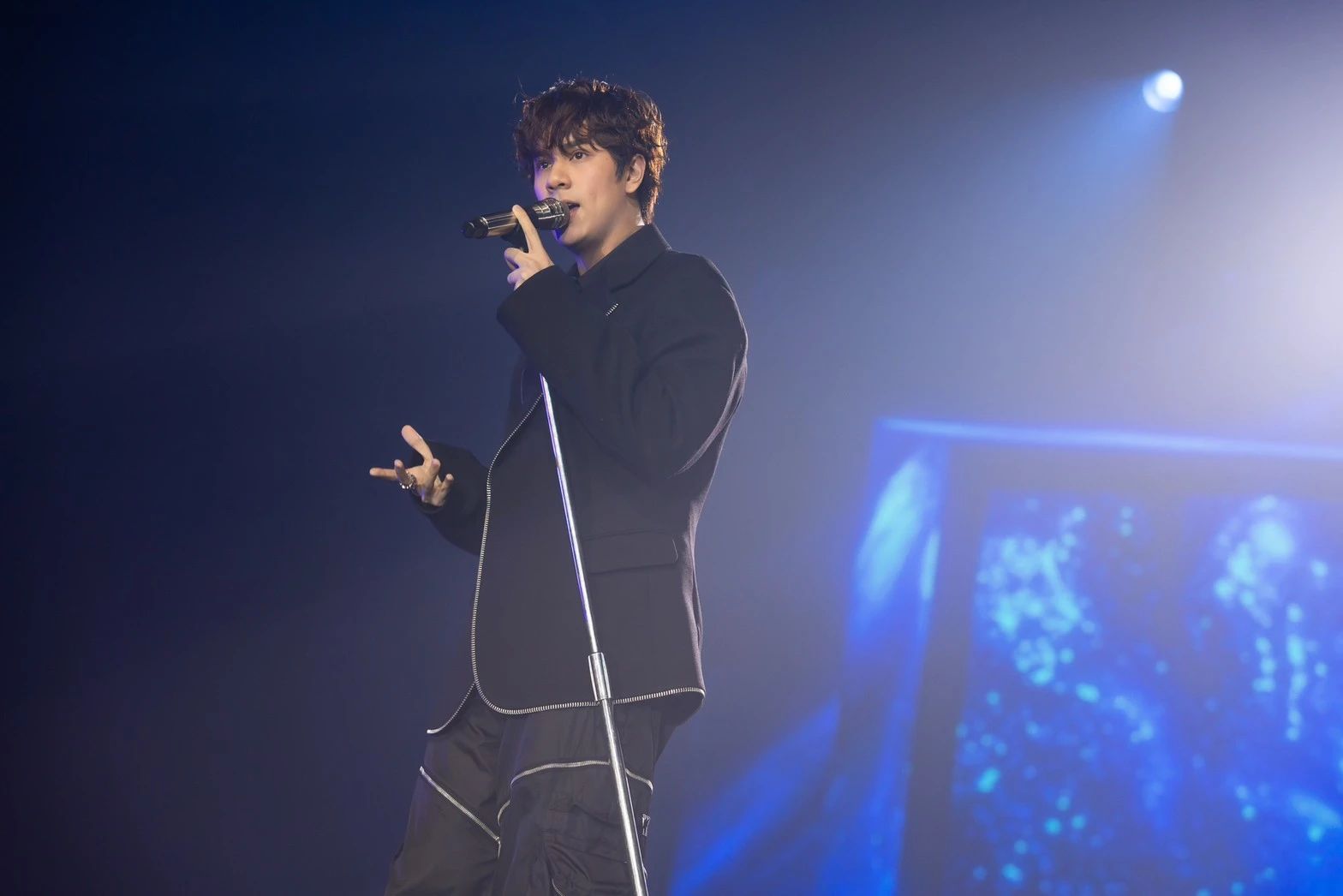 A person singing into a microphoneDescription automatically generated