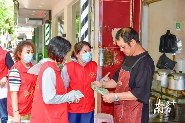 向商户发放科普宣传手册  南方+ 彭深 拍摄