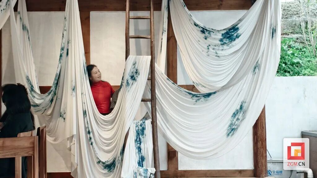 ▲游客在扎染艺术作品前打卡