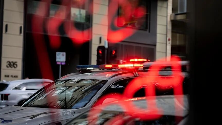 A Victoria Police car flashes sirens in Melbourne CBD.