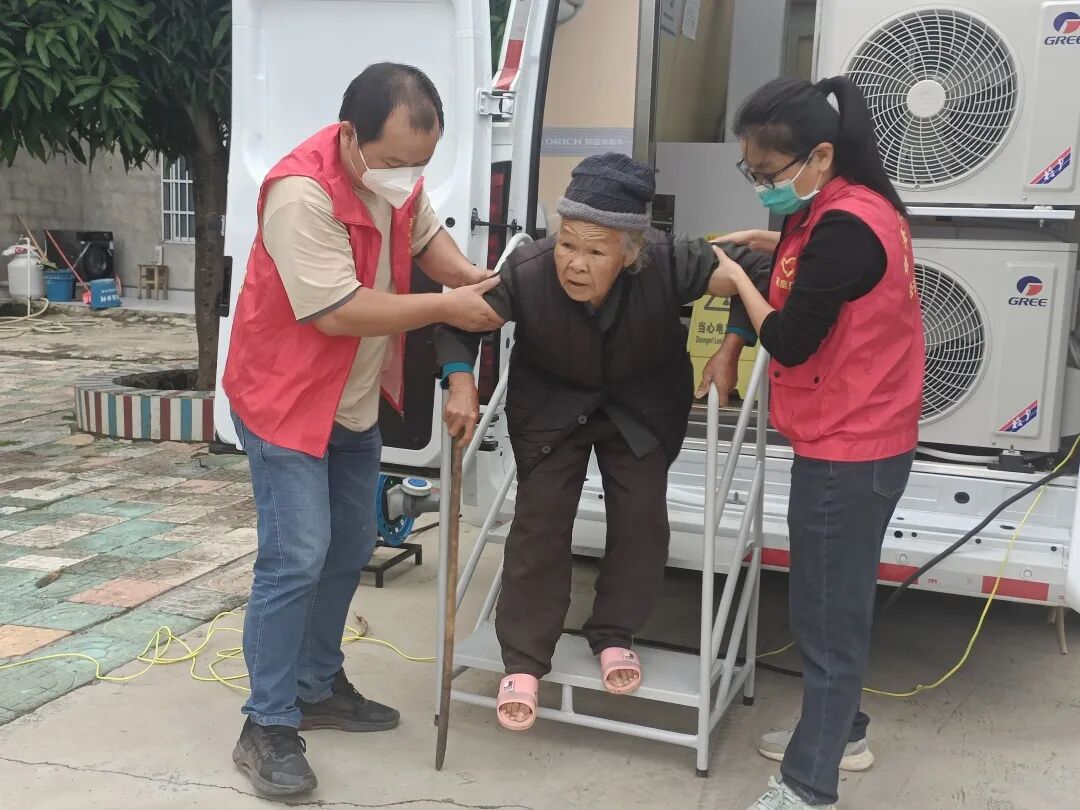 志愿者协助行动不便老人下车.jpg