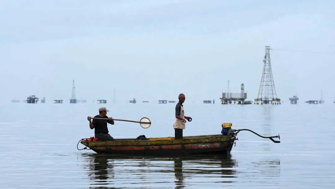 Fishermen cast their lines from a boat on Lake Maracaibo.