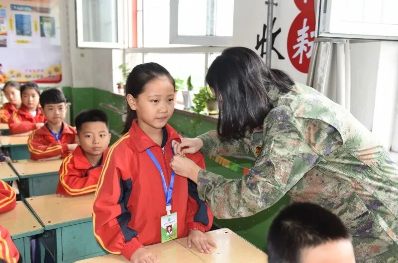02-民兵班队员为学生佩戴班徽胸针（1）.JPG