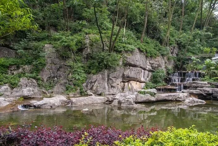 A small waterfall trickling into a pond in Seven Star Park, Guilin, China