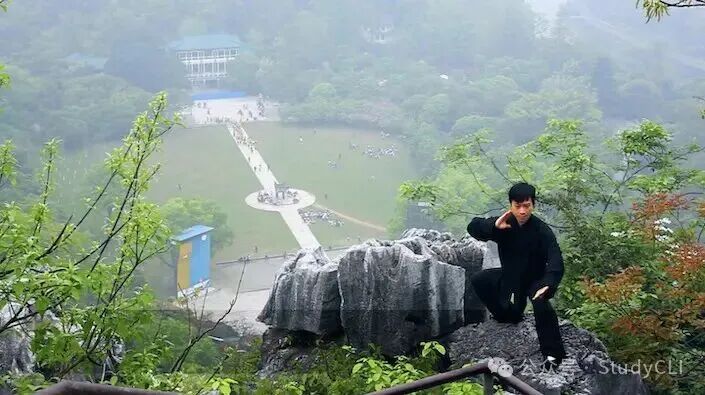 A Chinese man in black practicing tai chi on a mountain in Seven Star Park