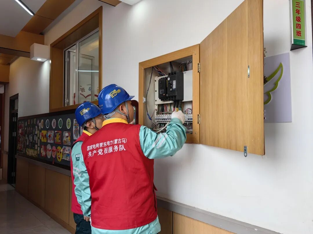 国家电网蒙东电力（通辽城西）蒙古马共产党员服务队队员检查学校走廊配电箱。.png